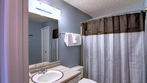 A bathroom with a sink, toilet, and a shower curtain.