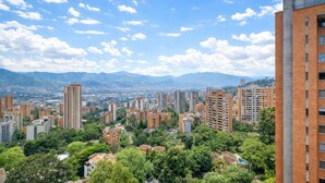 Un quartier résidentiel composé d’immeubles à étages, entouré de verdure et avec des montagnes en toile de fond.