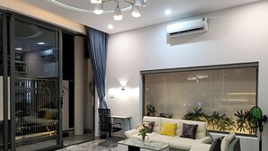 A modern living room with a sofa, coffee table, and a large window. - Aroma My Khe Beach (Da Nang)