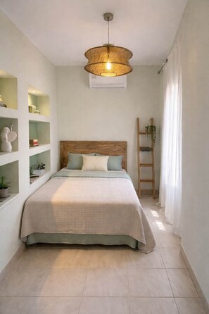 Camera da letto con un letto, una lampada a sospensione e scaffalature integrate con piante.