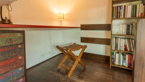 A room with a wooden stool, a bookshelf, and a wall-mounted lamp. - Magnificient Duplex in Old Antibes ! (Antibes)