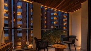 A balcony with two chairs and a small table, overlooking a building with multiple balconies. - Loft in Laureles - AC fast WiFi & private balcony (Medellín)