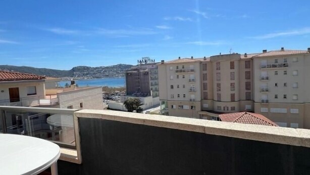 A hotel with a terrace, a view of the sea, and a building with balconies. - Beautiful duplex with sea view AV-72 (ROSES)