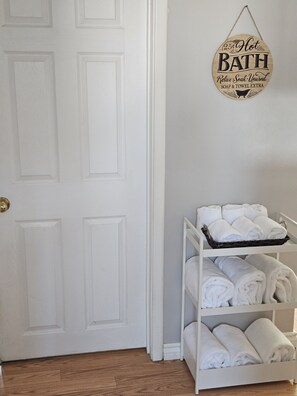 A white door with a sign above it that reads "25¢ Hot Bath Relax Soak Unwind Soap & Towel Extra".