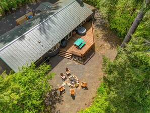 An aerial view of a cabin with a deck, outdoor seating, and a fire pit. - Packshack - Cozy Ski Cabin Mins From White Pass 2 Bedroom Home (Packwood)