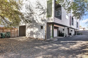 Stylish two-story home with a clean design, featuring a covered driveway and a small front yard.