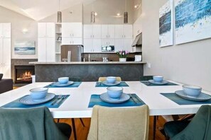 Enjoy meals in this kitchen with a central island, dining table, and cozy fire feature.