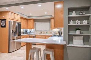 A modern kitchen with wooden cabinets, stainless steel appliances, and a central island. - Marbella Lane - Charming 4BR Bungalo for Relaxing Retreat (Fullerton)