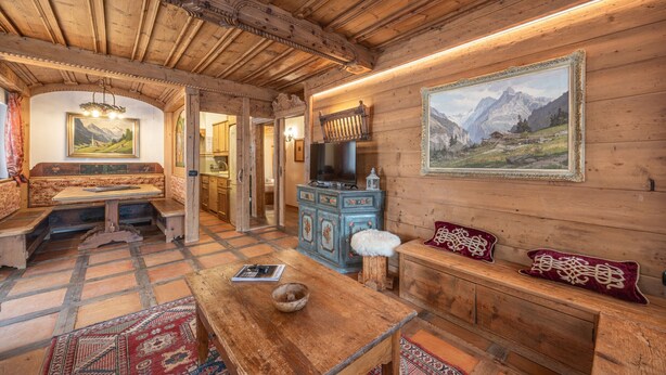 A wooden interior with a bench, a table, and a painting on the wall. - Casa Col, near the ski slopes with view of the Dolomites (Cortina d´Ampezzo)
