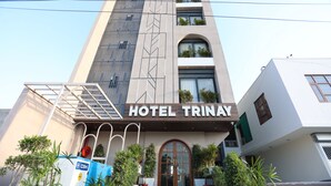 A modern hotel building with a prominent sign reading "HOTEL TRINAY". - Hotel Trinay (Jaipur)