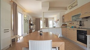 A modern kitchen with wooden cabinets, a built-in oven, and a large window. - Villa Malaspina - Hot Tub, 3 Bedrooms, Sleeps 6 (Alliste)