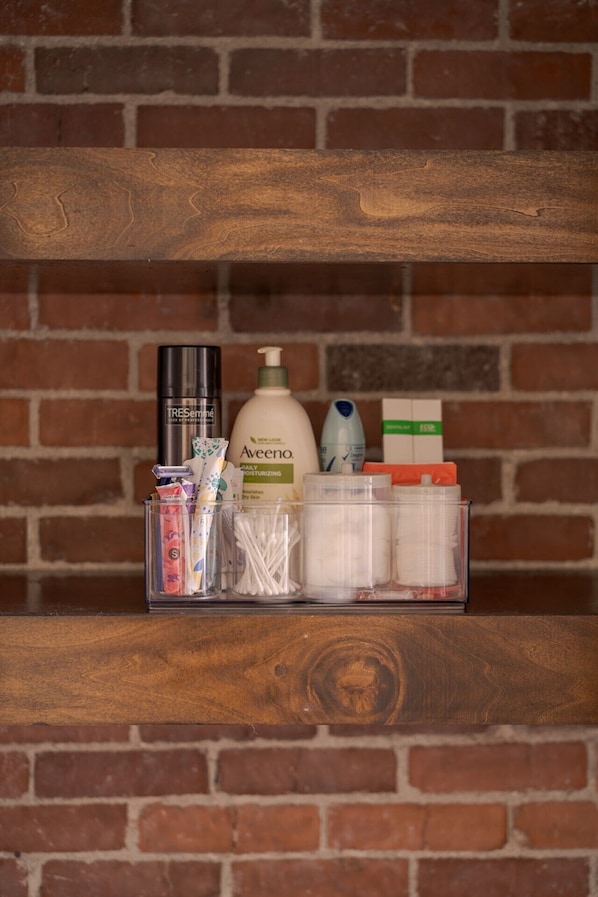 A shelf with toiletries including Aveeno lotion, a black bottle, and various other items.