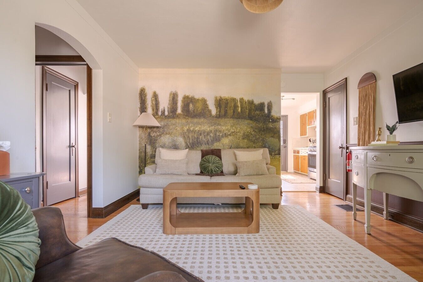 A living room with a sofa, coffee table, and a painting on the wall.