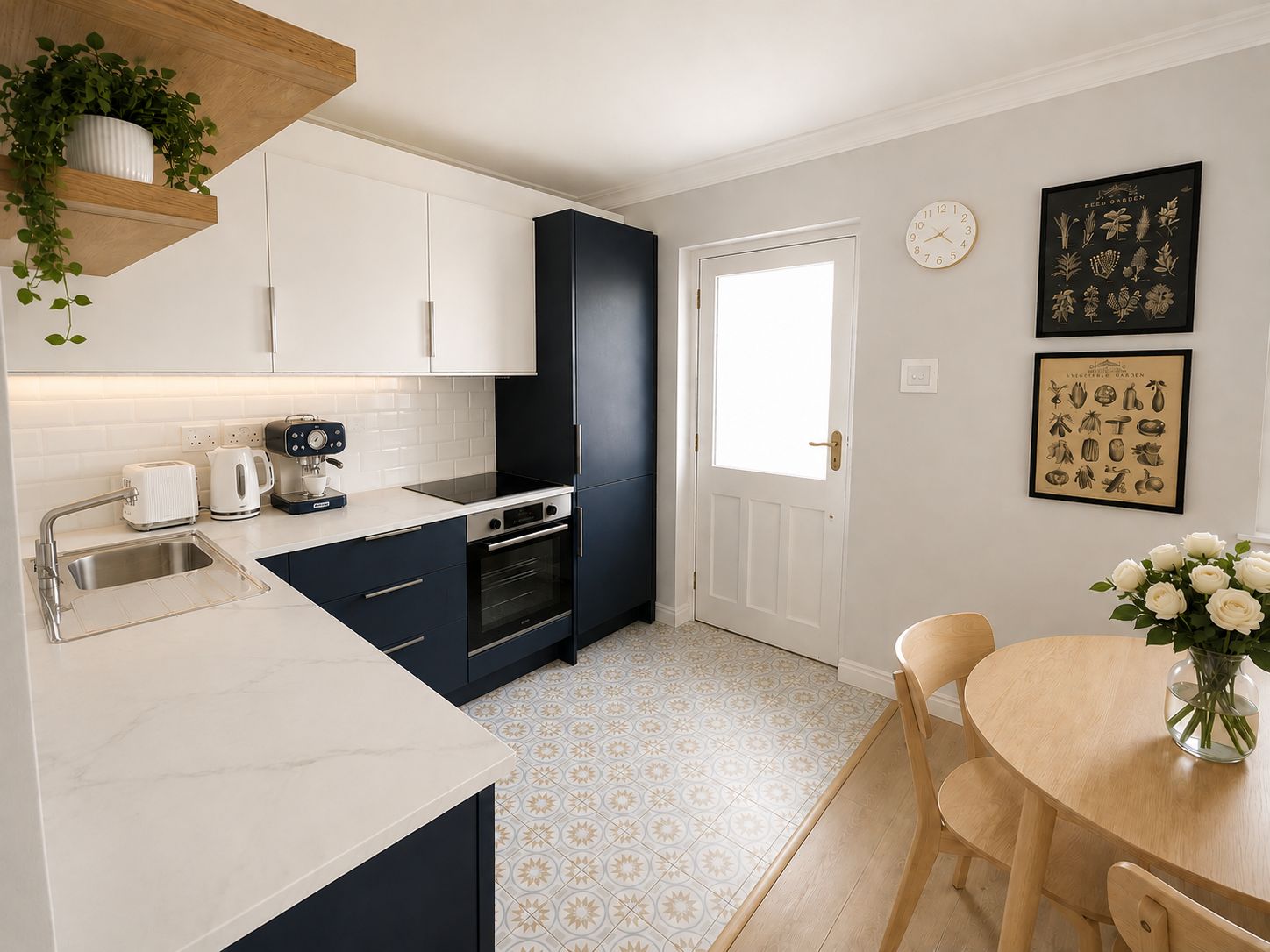 A modern kitchen with white cabinets, a black range hood, and a dining area with a wooden table and chairs.