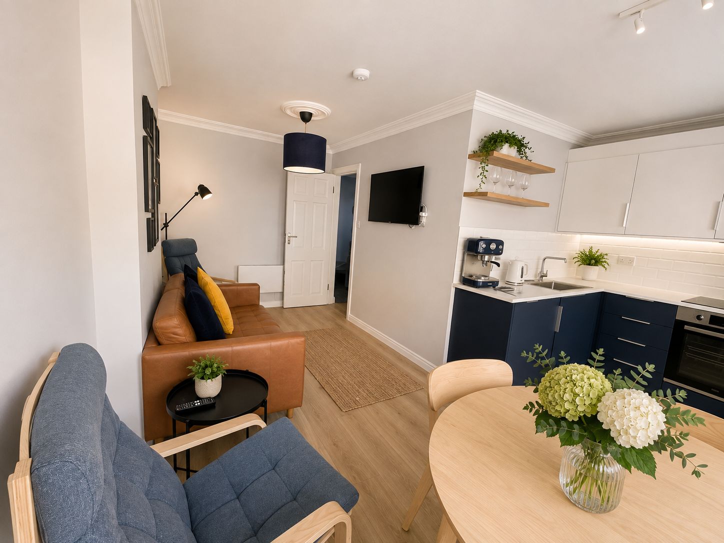 A modern apartment with a living room, a dining area, and a kitchen.