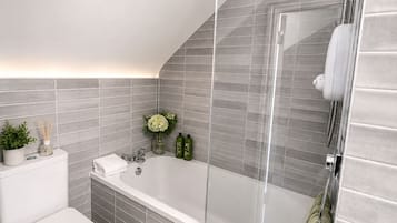 A modern bathroom with a shower, toilet, and sink.
