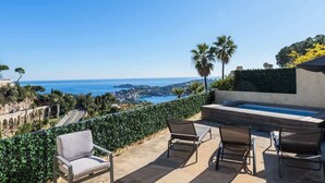 Terraza en la azotea con piscina, zona de estar y vistas a la costa.