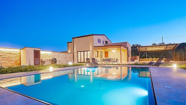 Uma casa moderna com piscina, móveis de exterior e área de varanda.
