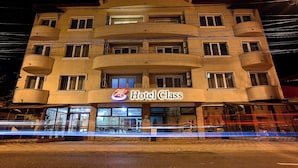 A multi-story hotel with balconies and a sign reading "Hotel Class".