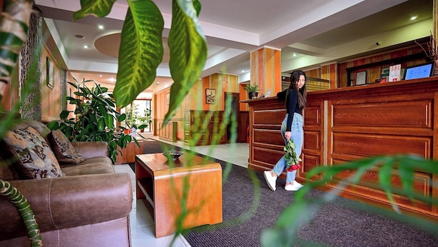 A hotel lobby with a reception desk, a sofa, and a coffee table.