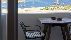 Ένα δωμάτιο με θέα στη θάλασσα, ένα ξύλινο τραπέζι και μια καρέκλα.