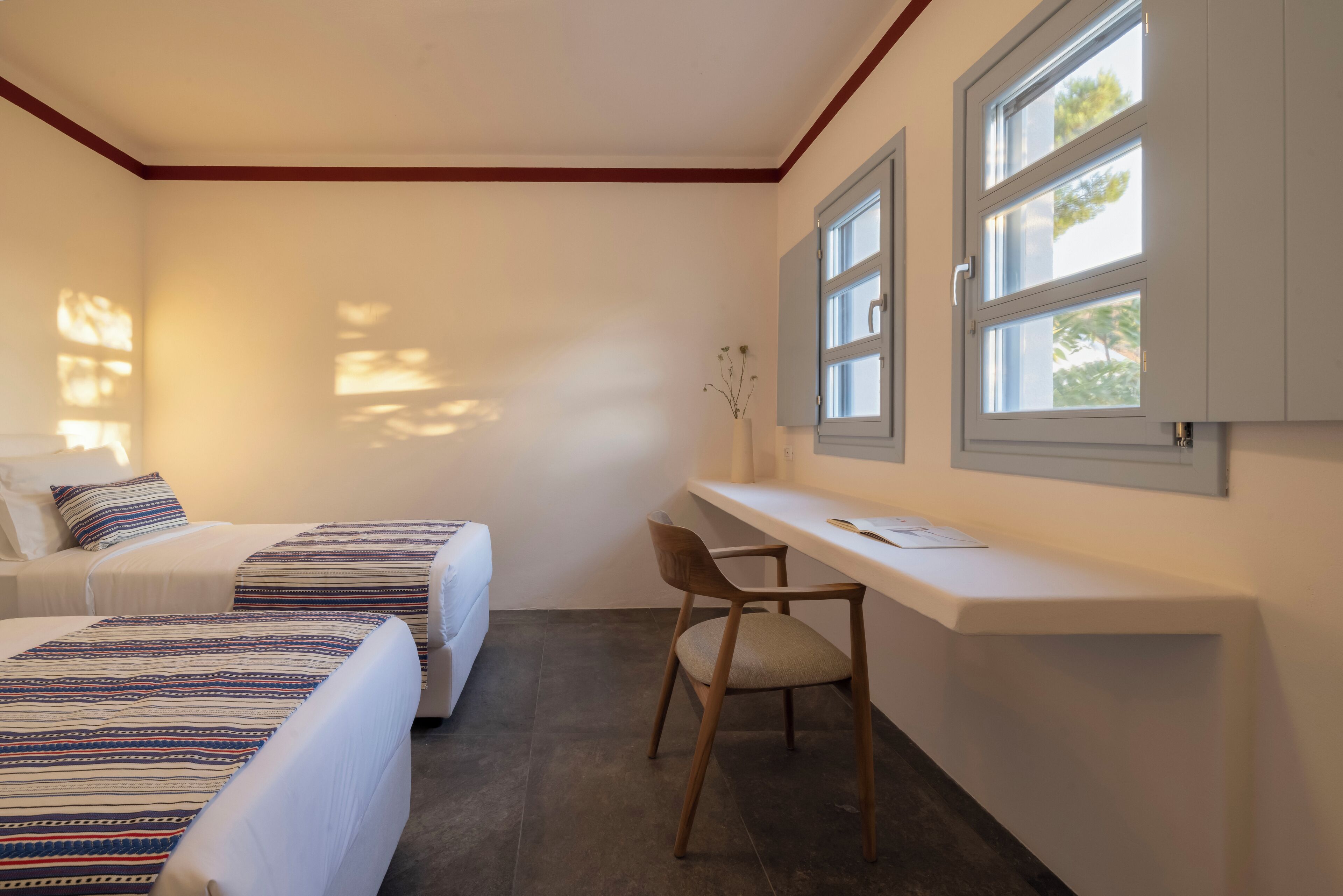 Une chambre avec deux lits, un bureau et une chaise.