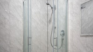 A modern bathroom with a glass-enclosed shower, a toilet, and a sink. - The Ocean Inn (Blackpool)