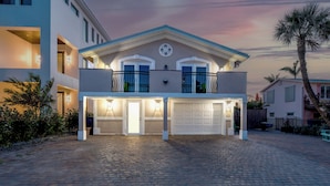 A two-story house with a garage, a balcony, and a driveway.