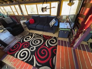 A cozy living area with a blue sofa, a red pillow, and a patterned rug. - Cozy Hippie Hideaway in the Heart of Bristol (Bristol)