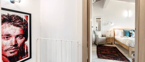 Un dormitorio moderno con una cama grande, mesitas de noche y una mesita auxiliar.