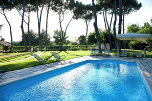 Ein Schwimmbad mit Liegestühlen und einer Pergola.