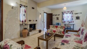Una sala de estar acogedora con chimenea, sofás de estampado floral y una mesa de centro de madera.