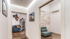 Ein modernes Wohnzimmer mit einem blauen Sofa, einem grünen Sessel und Holzboden.