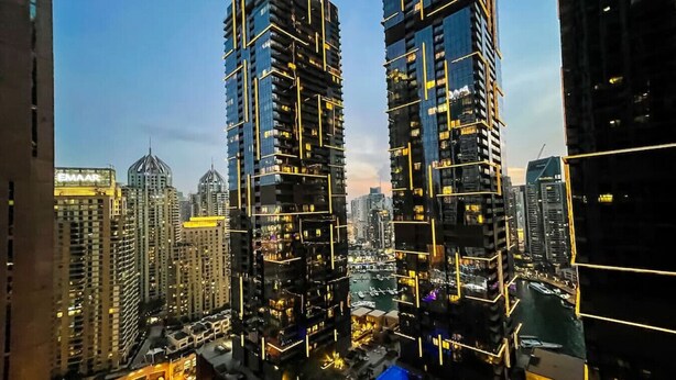 Un immeuble de grande hauteur doté d’une architecture moderne, avec de nombreux balcons et une façade en verre remarquable.