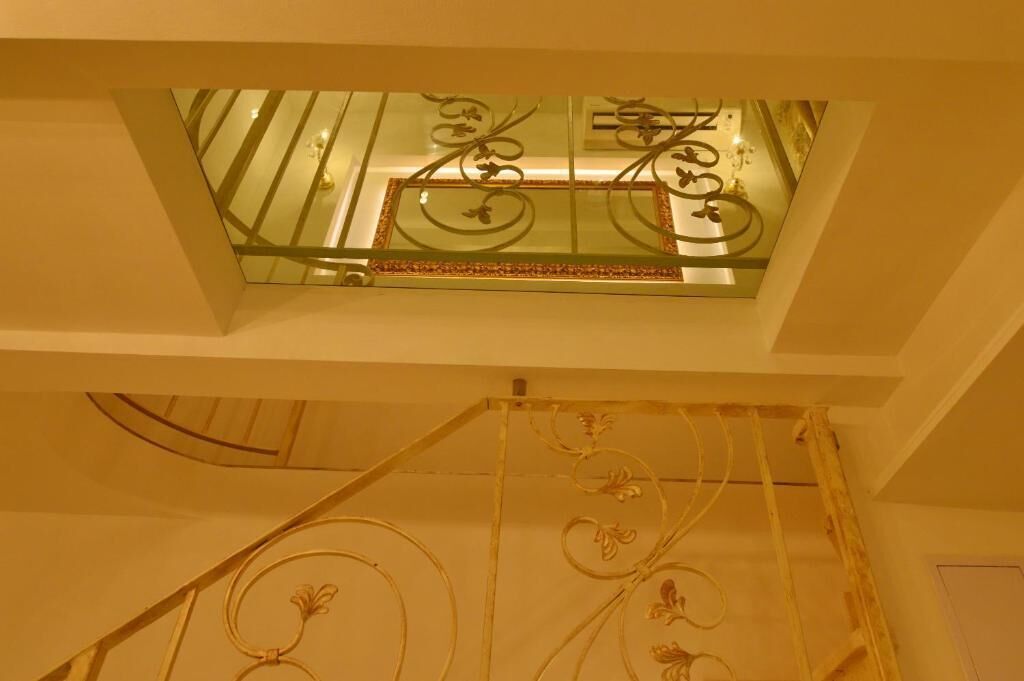 A glass balcony with decorative metal railings and a patterned ceiling.