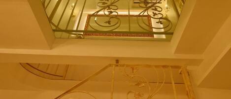 A glass balcony with decorative metal railings and a patterned ceiling.