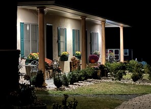 Een huis met veranda, zuilen en buitenmeubilair.