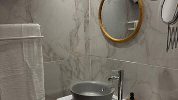 Een haardroger, handdoeken, zeep, toiletpapier