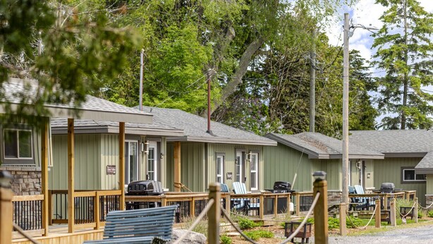 A row of motel-style cabins with outdoor seating and barbecue grills. - The Picton Beautiful Couple`s Getaway (Prince Edward)