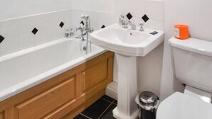 Une salle de bain avec une baignoire, un lavabo et des toilettes.