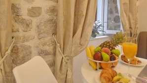 A breakfast table with fruit, juice, and croissants.
