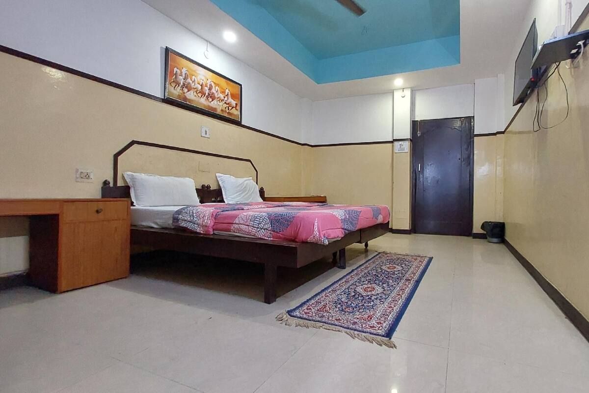 A bedroom with a bed, bedside table, and a rug.