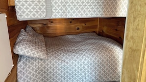 Un lit superposé avec une literie à motifs dans une chambre de cabane en bois.