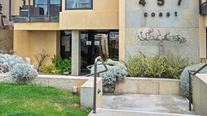 A multi-story building with balconies, a stone facade, and the address "457 coast" visible. - Seize the Day by Gather: 2BR Retreat w/ Views & Parking (La Jolla)