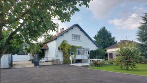 A two-story house with a white exterior and a sloped roof.