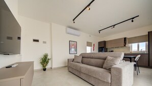 Uma sala de estar moderna com um sofá, uma mesinha e um vaso de planta.