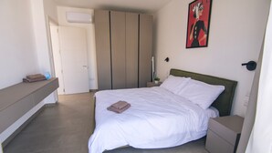Une chambre à coucher comprenant un lit, une table de chevet, une commode et une armoire.