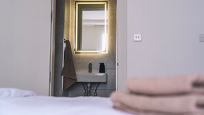 A hotel bathroom with a sink, mirror, and towel rack. - The Valley Collection - Suite A10 (Ix-Xagħra)