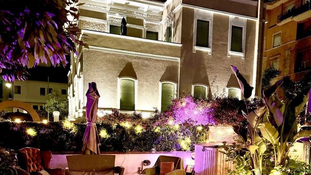 Eine Außenpatio-Terrasse mit Esstisch, Stühlen und einer Statue.