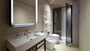 A modern bathroom with a large mirror, two sinks, a toilet, and a glass shower enclosure. - Scarlatti Hotel Milano (Milan)